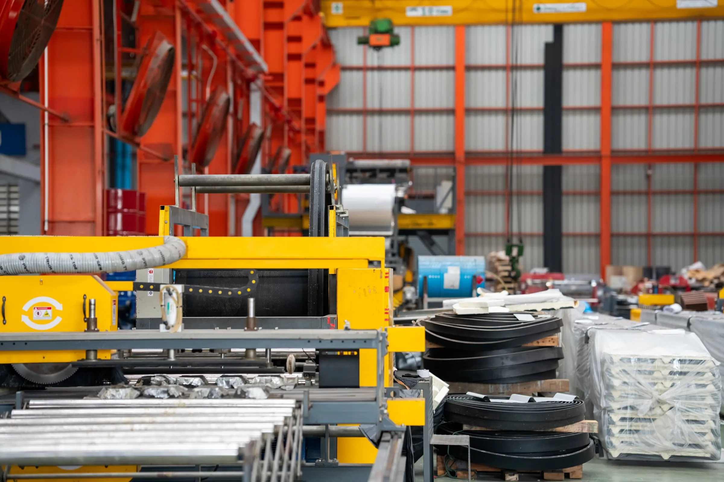 Fabrication shop floor with steel coils and canopy parts